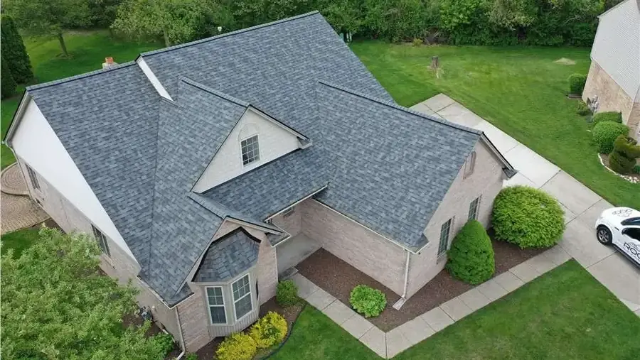 New gray shingle roof on a brick home with a bay window